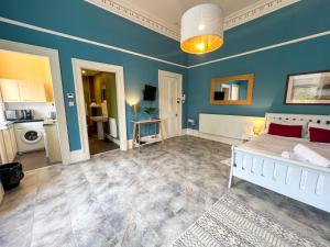 格拉斯哥Cozy Studio Apartment of Glasgows West End的卧室配有白色的床和蓝色的墙壁