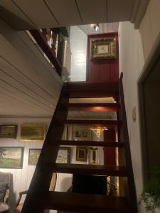 斯帕La Maisonnette des Hêtres Rouges的楼梯通往带绘画的房间