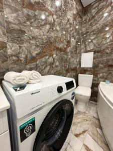 阿特劳Aportament in Abyroy Residence的一间带卫生间的浴室内的洗衣机