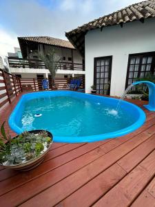 邦比尼亚斯Pousada Aconchego do Beija Flor的木制甲板上的游泳池,设有喷泉