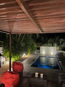 黑河区Calme et Bien-Être « Villa Sous Le Manguier »的一个带红色椅子和木制天花板的游泳池