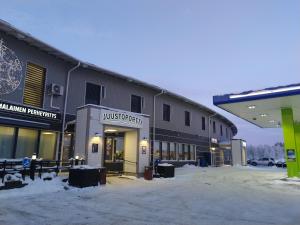 凯尔赛迈基Hotelli Kärsämäki的前面有雪盖停车场的建筑