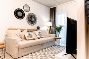 戈莱纽夫Hop & Lulu Premium Apartments的客厅配有白色沙发和电视