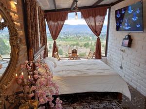 拉塔昆加Tiny Home Glamping en Latacunga的一间卧室设有一张床和一个大窗户