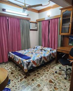达卡Dhanmondi Furnished Lake View Apartment的一间卧室配有一张床、一张书桌和窗帘