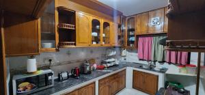 达卡Dhanmondi Furnished Lake View Apartment的一间带木制橱柜和微波炉的厨房