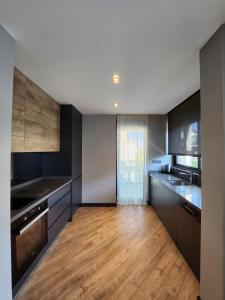 安塔利亚Z-Suites的大型厨房铺有木地板,设有大窗户。