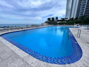 迈阿密海滩Lovely beaches ocean & city view的毗邻大海的大型蓝色游泳池