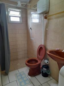 特拉曼达伊Linda kitnet perto do mar!的浴室设有棕色的卫生间和水槽。