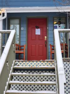 怀特霍斯隐谷住宿加早餐酒店的蓝色房子的红色门,有楼梯