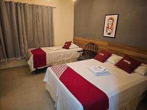 里约博尼图HOTEL INDIANO的一间酒店客房,房间内设有两张床