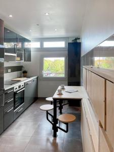 雷恩Auteuil • 4 Chambres • Wifi • Métro à 400m的厨房配有桌子和两张凳子