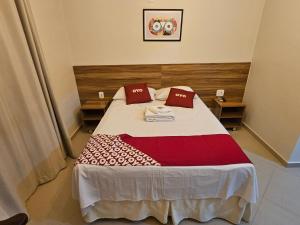 里约博尼图HOTEL INDIANO的一间卧室配有一张带两个红色枕头的床