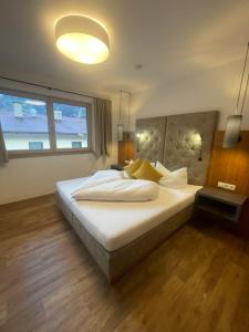 乌登斯Apart Mountain的一间卧室配有一张带白色床单和黄色枕头的大床。