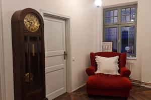 HoymHistorisches Badehaus的房间里的时钟和红色椅子