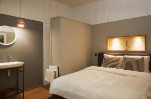MasléonVilla Combade的一间卧室配有床、水槽和镜子