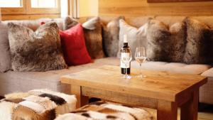 莫尔济讷Chalet Mimi的客厅配有一瓶葡萄酒和桌子上的玻璃杯