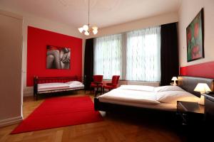 汉堡阿姆斯特丹酒店的一间卧室设有一张床和红色的墙壁