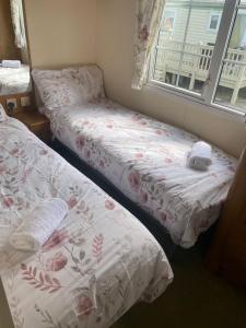 阿兴顿Cosy Cottage Caravan的带窗户的客房内设有两张单人床。