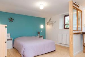 Saint-Martin-des-EntréesMaisonnette duplex avec jacuzzi/sauna attenant的卧室配有白色的床和蓝色的墙壁