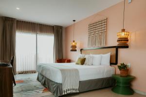 图卢姆Selina Tulum Downtown的卧室设有一张白色大床和两个窗户。
