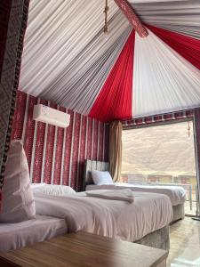 DisahV D C Wadi Rum的红色和白色天花板的客房内的两张床