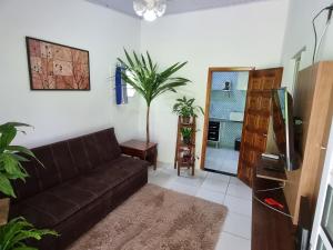 卡拉瓜塔图巴Kitnets em Caraguatatuba的客厅配有棕色皮沙发