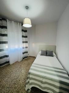 巴伦西亚德亚尔坎塔拉Apartamento Almazara的一间卧室配有带条纹毯子的床