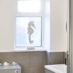 安布尔Avocet Cottage Amble的浴室内装饰有海马的窗户