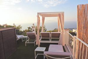 阿纳卡普里帕拉迪索卡普里住宿加早餐旅馆的一个带椅子的阳台和一个凉亭