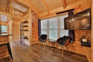 查塔努加Thomas Cabin Forest Tiny Cabin With Hot Tub的客厅配有电视和桌椅