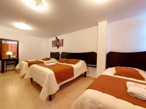基多HOSTAL MURGEON BOUTIQUE的一间酒店客房,房间内设有三张床