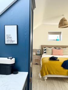 韦克斯福德The Loft Curracloe, on Wexfords Coastal Scenic Route的一间卧室设有蓝色的墙壁、一张床和一个水槽