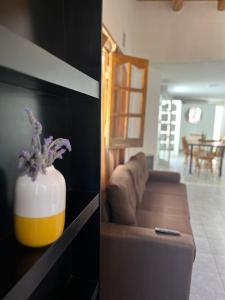 卢汉德库约Complejo Lamadrid - semiprivado的客厅配有沙发和鲜花花瓶