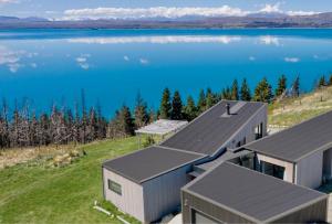 普卡基湖Kārearea Lakehouse at Lake Pukaki的湖泊边缘房屋的空中景观