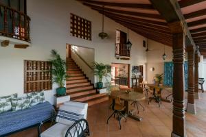 圣菲德安蒂奥基亚Hotel Boutique Al Alma的客厅设有楼梯和桌椅