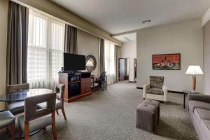 新奥尔良Drury Plaza Hotel New Orleans的一间客厅,客厅配有沙发和电视,位于酒店的房间