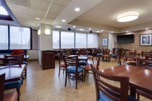 塞克斯顿塞克斯顿梨树德鲁酒店的用餐室设有木桌、椅子和窗户。