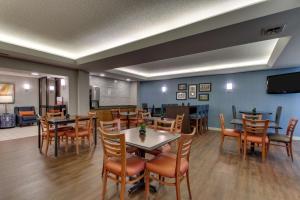 开普吉拉多西开普吉拉多梨树酒店的餐厅设有桌椅和平面电视。