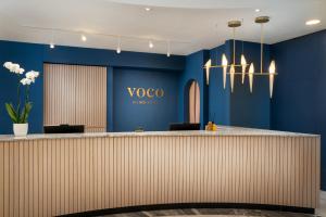 维也纳voco Vienna Prater, an IHG Hotel的大堂设有蓝色的墙壁和墙上的瓦亚标志