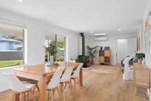 麦克拉伦谷The Arches ~ Style, location and spacious living!的一间带木桌和白色椅子的用餐室