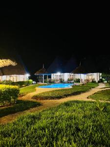 南威MITI Beach Bungalows的夜间带游泳池的度假村