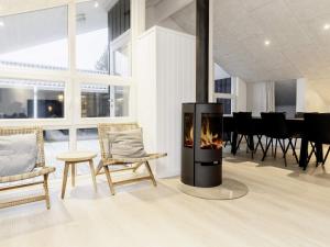 耶鲁普Holiday Home Brattenvej的客厅设有壁炉、椅子和桌子