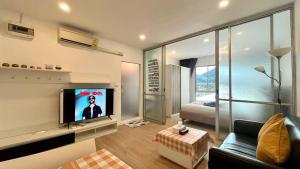 卡图Top Floor One Br Apartment Between Patonghkt City的带沙发和平面电视的客厅