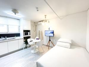 仁川市Koin Guesthouse Incheon airport的白色卧室配有床和书桌