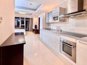 青岛青岛易达屋酒店公寓的厨房配有白色橱柜和炉灶烤箱。