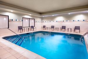 丹伯里丹波利万怡酒店的酒店客房的游泳池配有桌椅