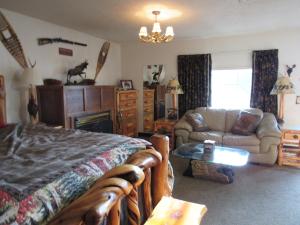 CrescentThe Woodsman Country Lodge Motel的一间卧室配有一张床、一张沙发和一张桌子