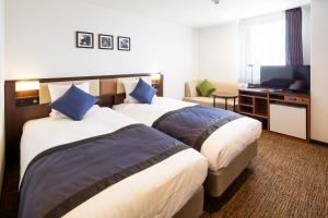 金泽MYSTAYS 金泽城堡酒店的酒店客房设有两张床和一台平面电视。