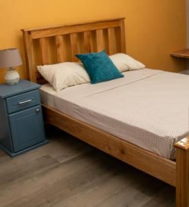 CanaanComfi Spaces的一张带木架和蓝色床头柜的床